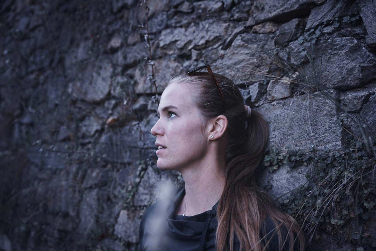 portrét ženy u kamenné zdi