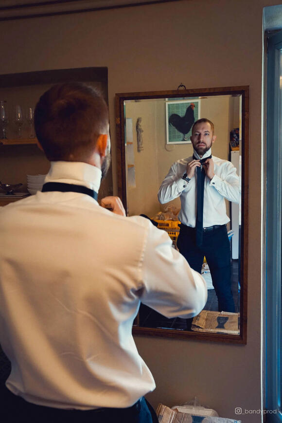muž v bílé košili před zrcadlem